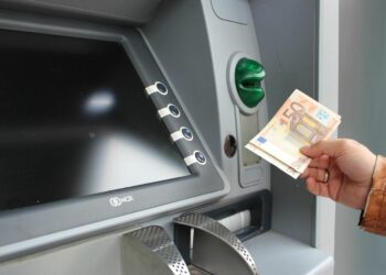 Eine Person am Land behebt Geld von einem Bankomaten im Ort.