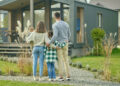 Familie blickt auf Einfamilienhaus – Symbolbild für Wohnbaudarlehen in Niederösterreich