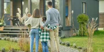 Familie blickt auf Einfamilienhaus – Symbolbild für Wohnbaudarlehen in Niederösterreich