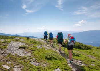 Symbolbild: Jugendliche wandern durch die grüne Berglandschaft der Karpaten.