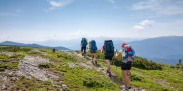 Symbolbild: Jugendliche wandern durch die grüne Berglandschaft der Karpaten.