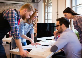 Das Symbolbild zeigt konzentriertes Arbeiten eines Teams in einem Co-Working-Space.