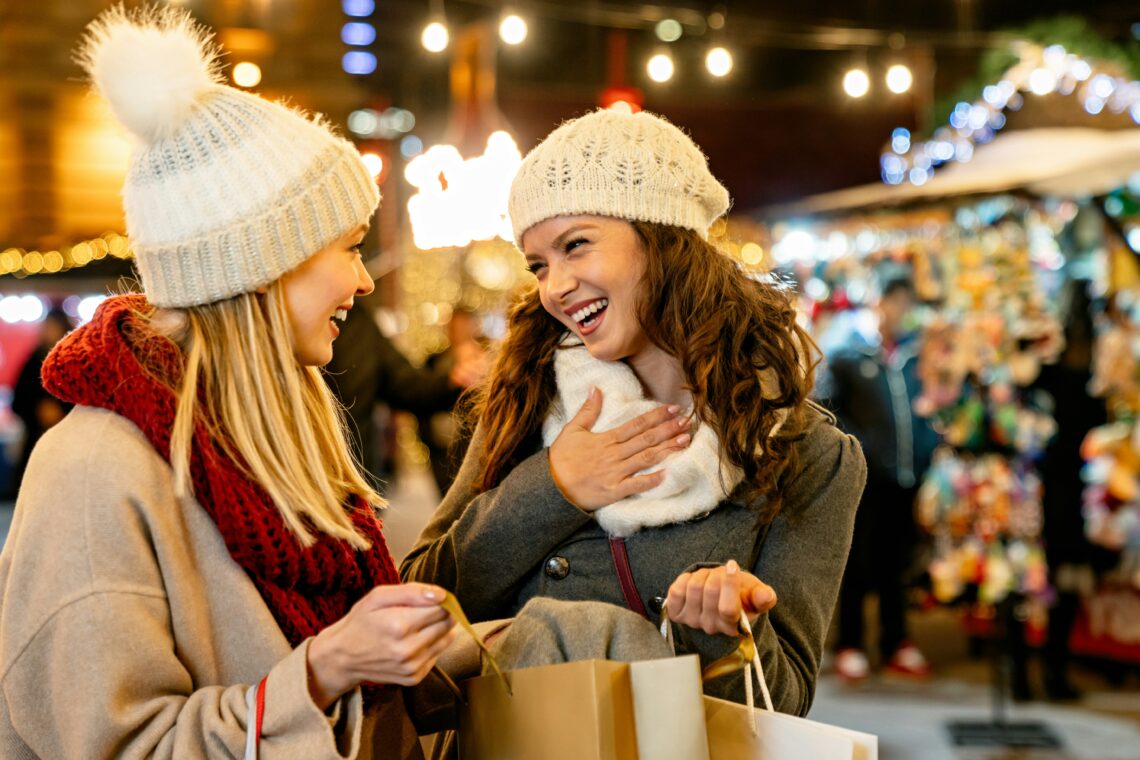 Das Bild zeigt zwei junge Frauen beim Besuch auf einem Weihnachtsmarkt.