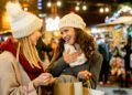 Das Bild zeigt zwei junge Frauen beim Besuch auf einem Weihnachtsmarkt.