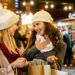 Das Bild zeigt zwei junge Frauen beim Besuch auf einem Weihnachtsmarkt.