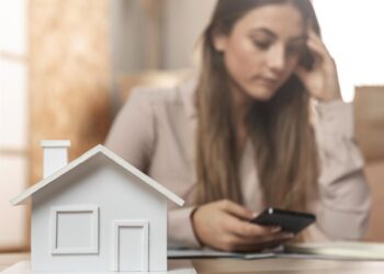 Besorgte junge Frau als Symbol für die Entwicklung des Immobilienmarkts in Niederösterreich.