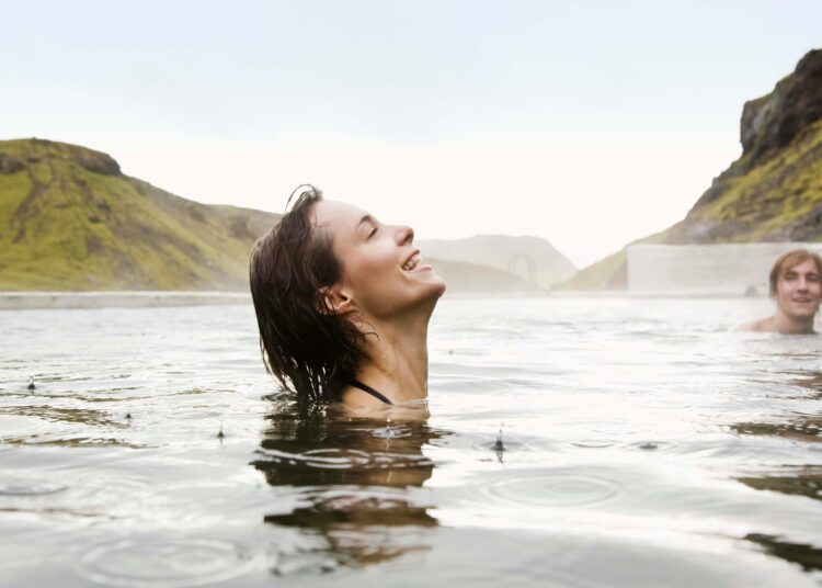 Symbolbild einer Frau, die in einer Thermalquelle badet