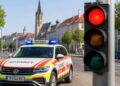 Symbolbild zeigt einen Notarztwagen und eine rote Ampel, um die aktuelle Versorgungslage zu veranschaulichen.