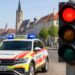 Symbolbild zeigt einen Notarztwagen und eine rote Ampel, um die aktuelle Versorgungslage zu veranschaulichen.