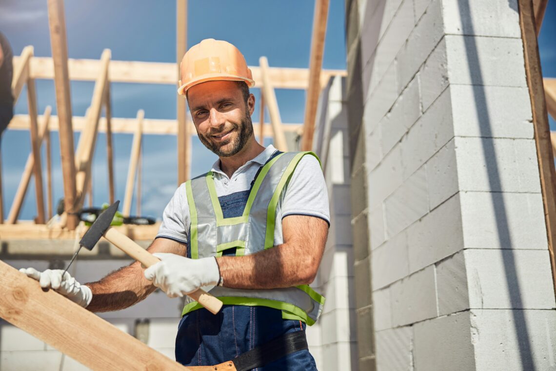 Freundlicher Bauarbeiter bei der Arbeit im Freien.