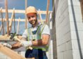 Freundlicher Bauarbeiter bei der Arbeit im Freien.