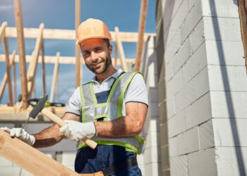 Freundlicher Bauarbeiter bei der Arbeit im Freien.