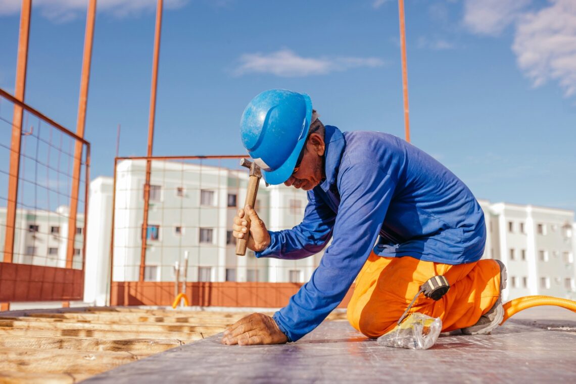 Ein Mann in Arbeitskleidung arbeitet auf einer Baustelle.