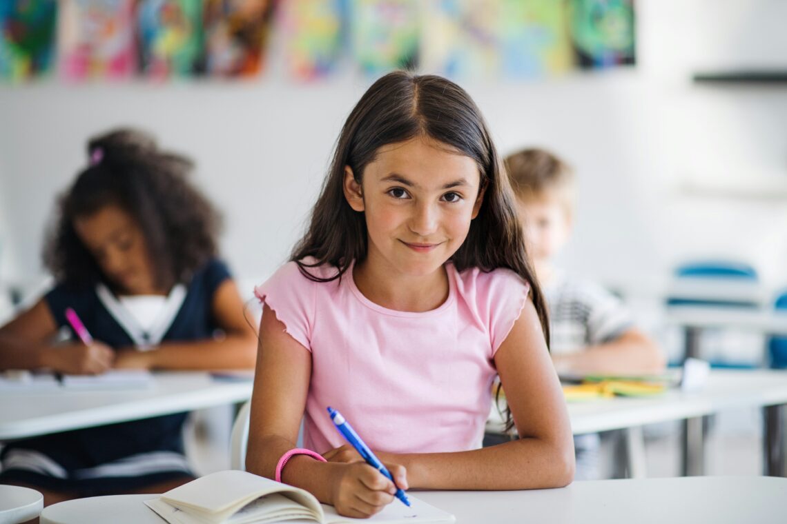 Freundlich lächelndes Mädchen im Klassenzimmer