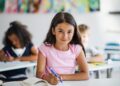 Freundlich lächelndes Mädchen im Klassenzimmer