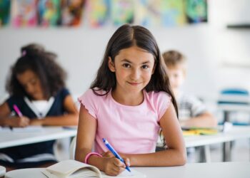 Freundlich lächelndes Mädchen im Klassenzimmer