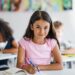 Freundlich lächelndes Mädchen im Klassenzimmer